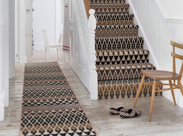 Close-up of a patterned stair runner carpet on wooden stairs